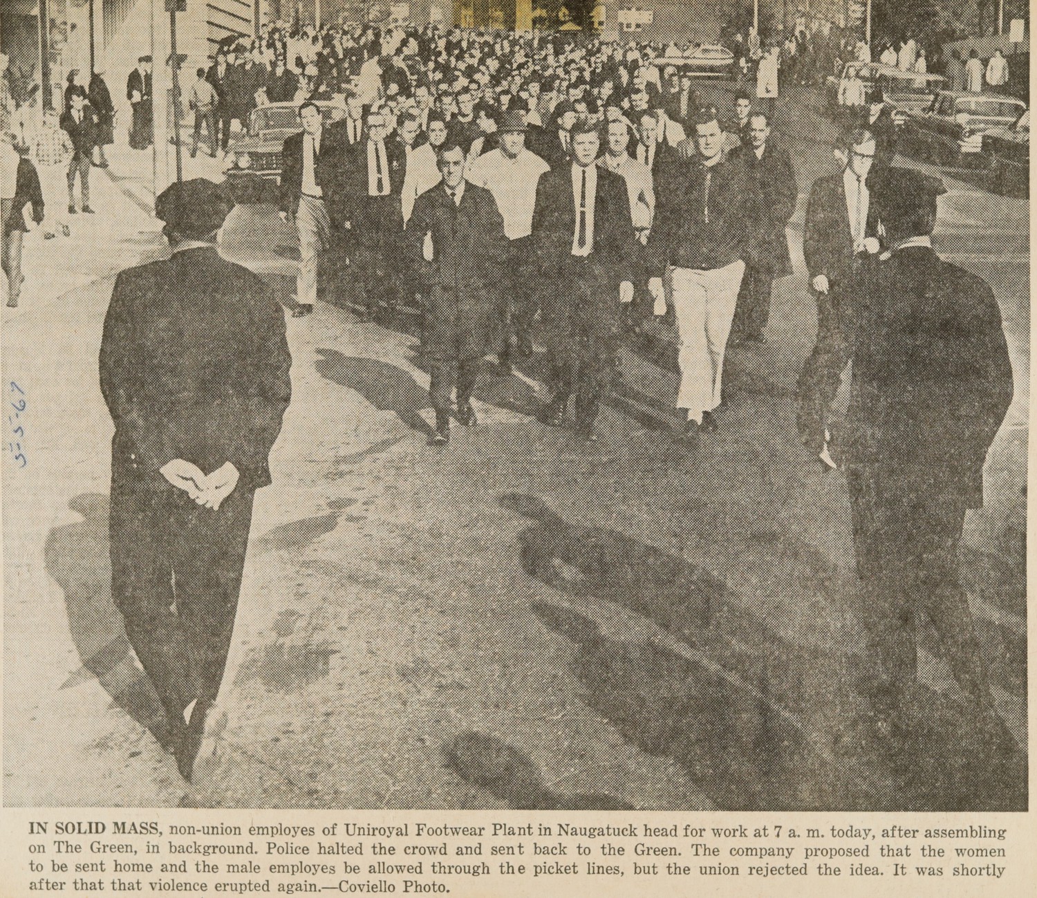 IN SOLID MASS, non-union employes of Uniroyal Footwear Plant in Naugatuck head for work at 7 a.m. today, after assembling on The Green, in background. Police halted the crowd and sent back to the Green. The company proposed that the women be sent home and the male employes be allowed through the picket lines, but the union rejected the idea. It was shortly after that that violence erupted again.—Coviello Photo.