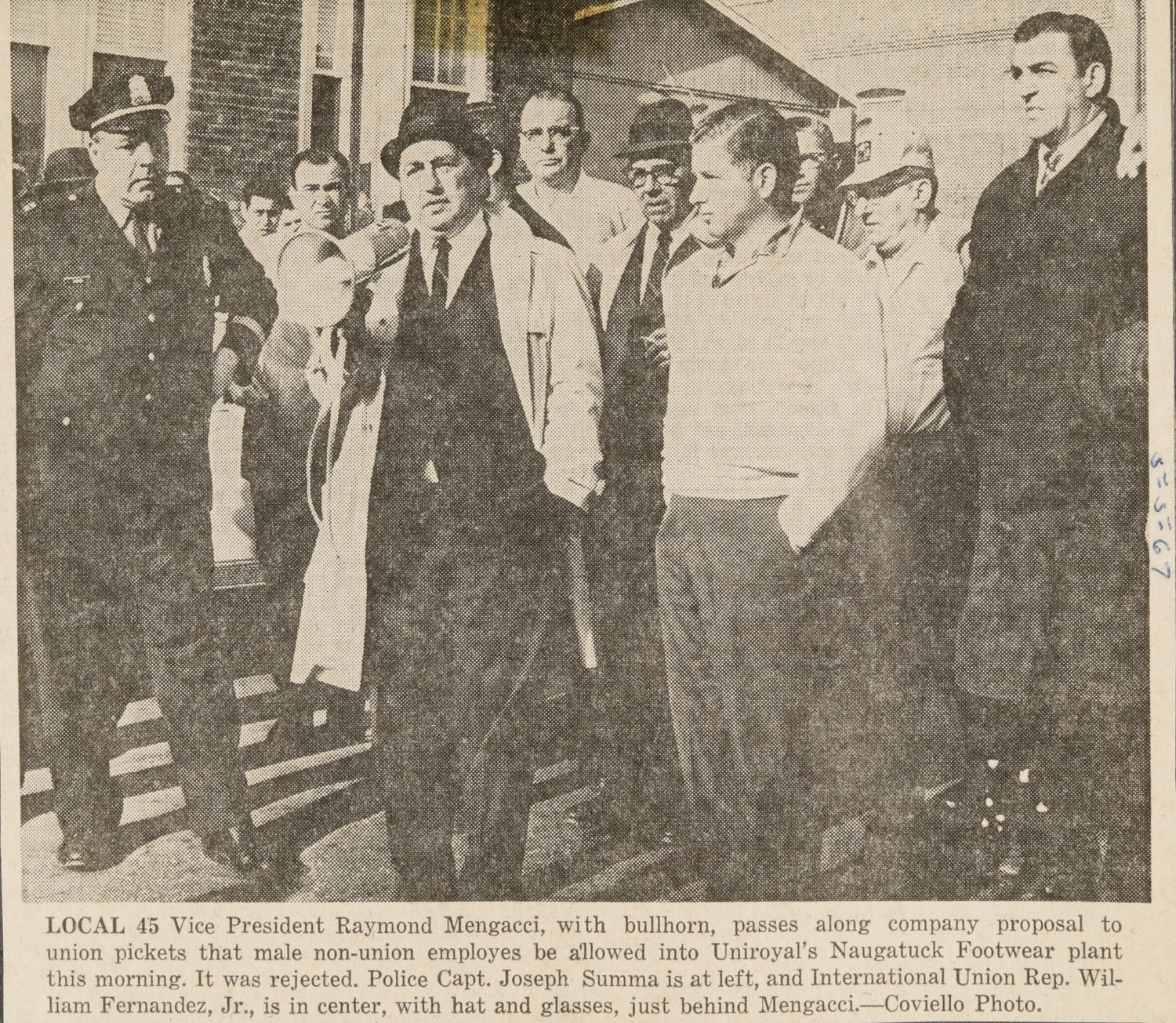 LOCAL 45 Vice President Raymond Mengacci, with bullhorn, passes along company proposal to union pickets that male non-union employes be allowed into Uniroyal's Naugatuck Footwear plant this morning. It was rejected. Police Capt. Joseph Summa is at left, and International Union Rep. William Fernandez, Jr., is in center, with hat and glasses, just behind Mengacci.