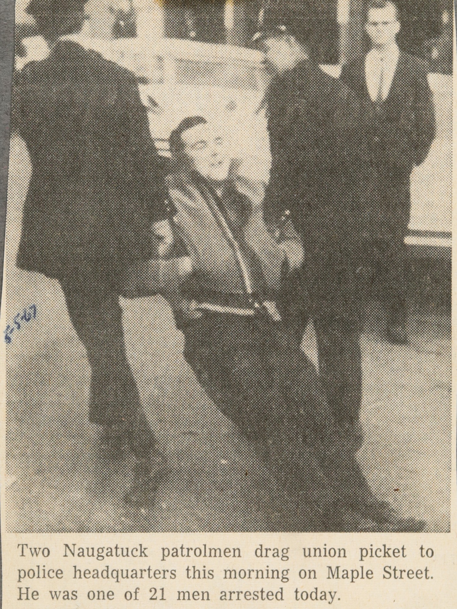 Two Naugatuck patrolmen drag union picket to police headquarters this morning on Maple Street. He was one of 21 men arrested today.