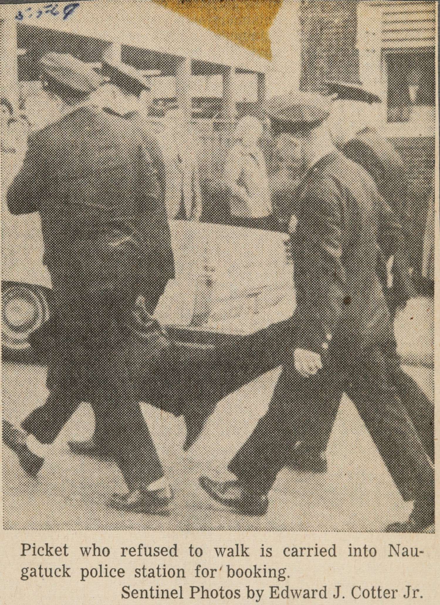 Picket who refused to walk is carried into Naugatuck police station for' booking.