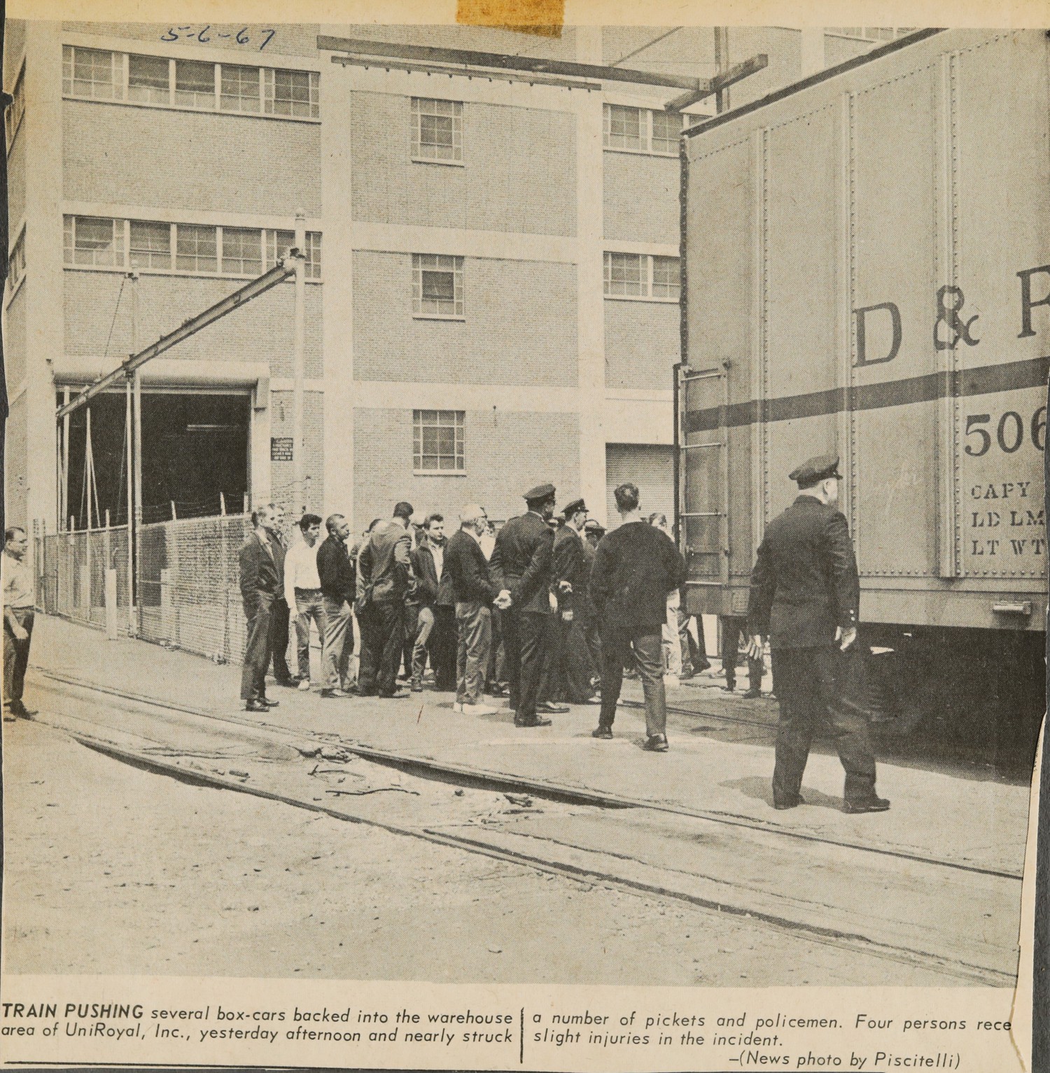 TRAIN PUSHING several box-cars backed into the warehouse