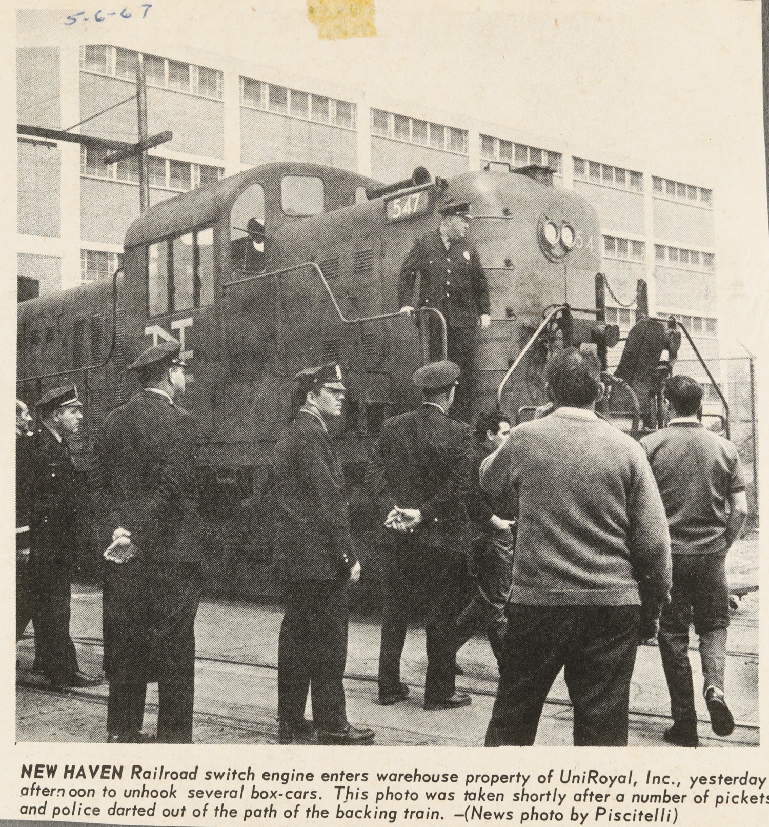 NEW HAVEN Railroad switch engine enters warehouse property of UniRoyal, Inc., yesterday afternoon to unhook several box-cars. This photo was taken shortly after a number of pickets and police darted out of the path of the backing train.